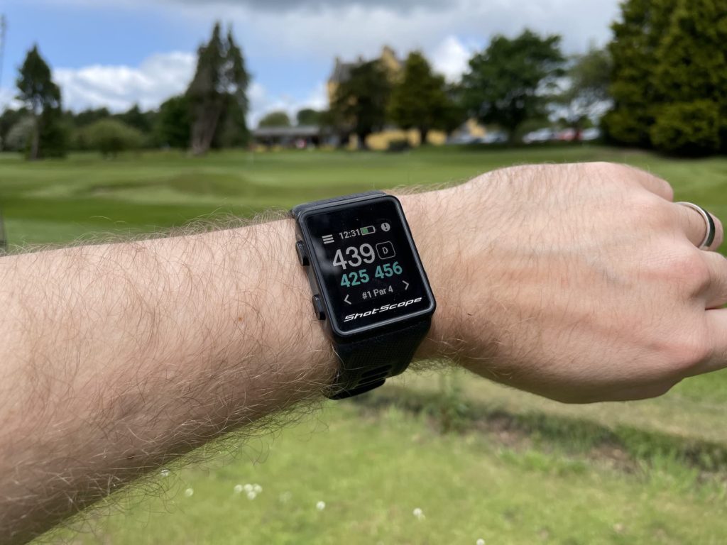 Shot Scope V3 golf watch on wrist showing GPS information at golf course