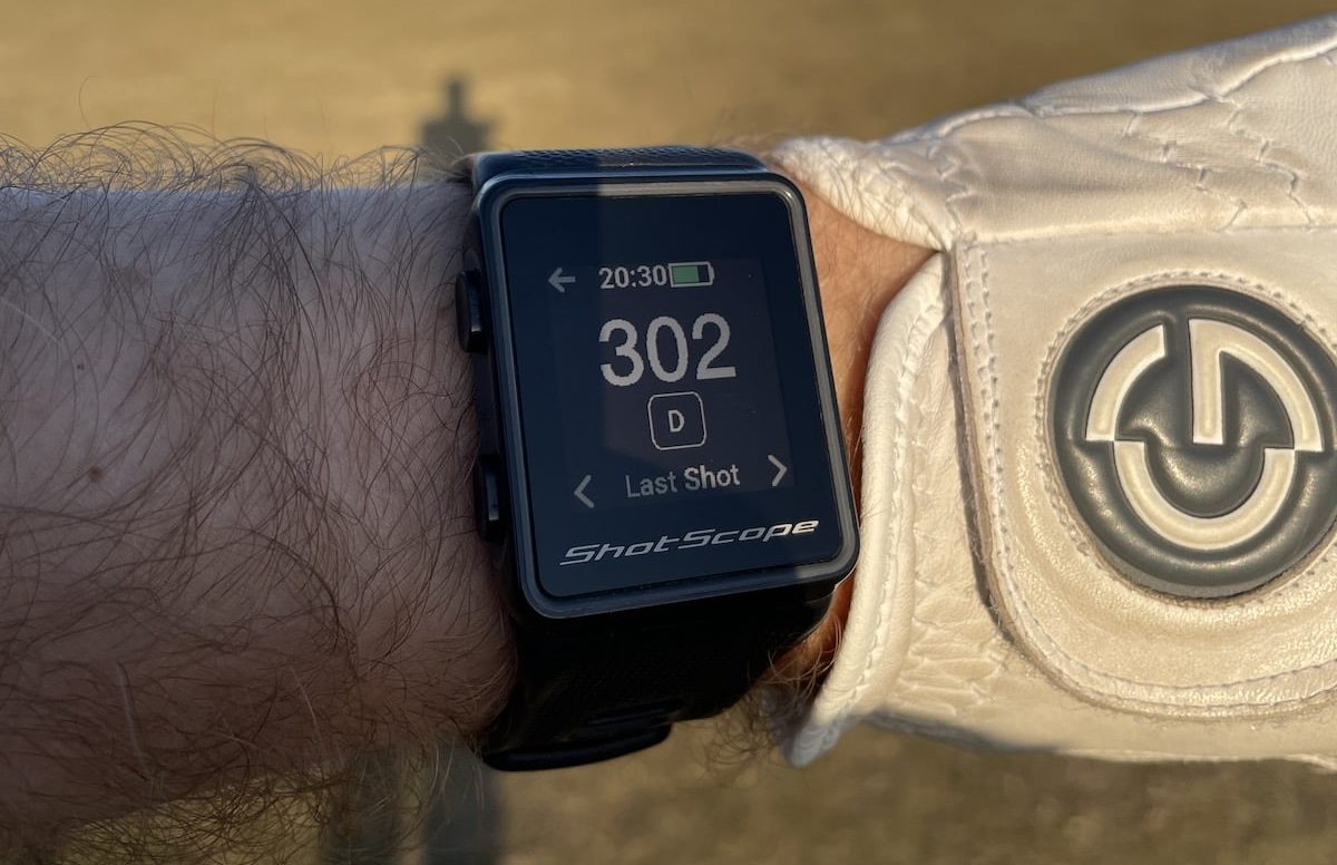 Shot Scope V3 golf watch on a man's wrist showing longest drive screen