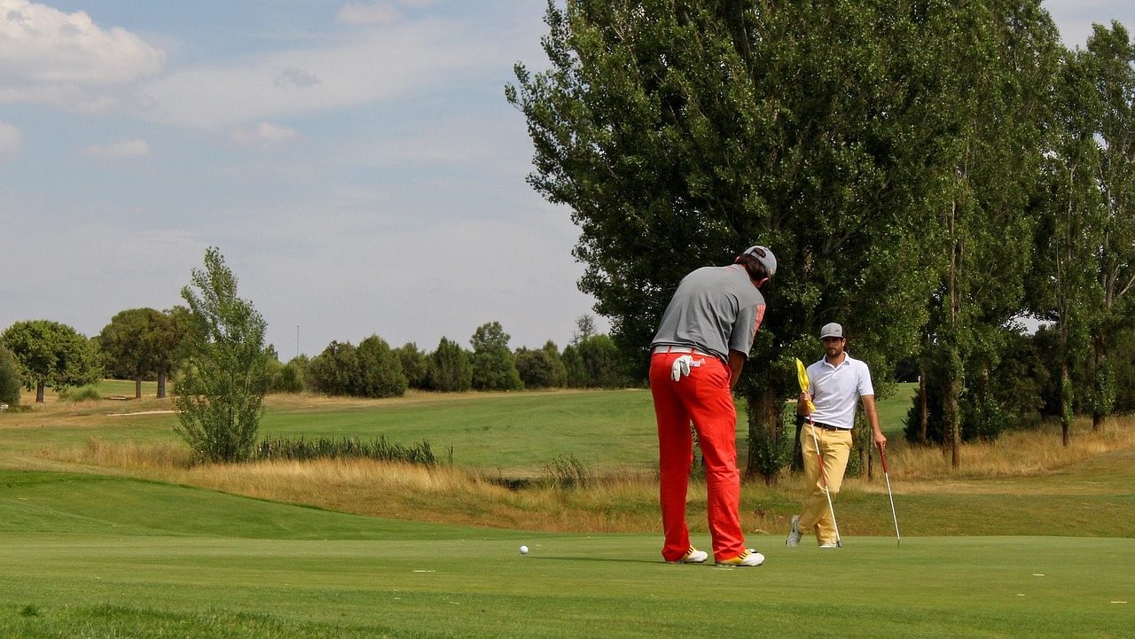 two men golfing together - putting green