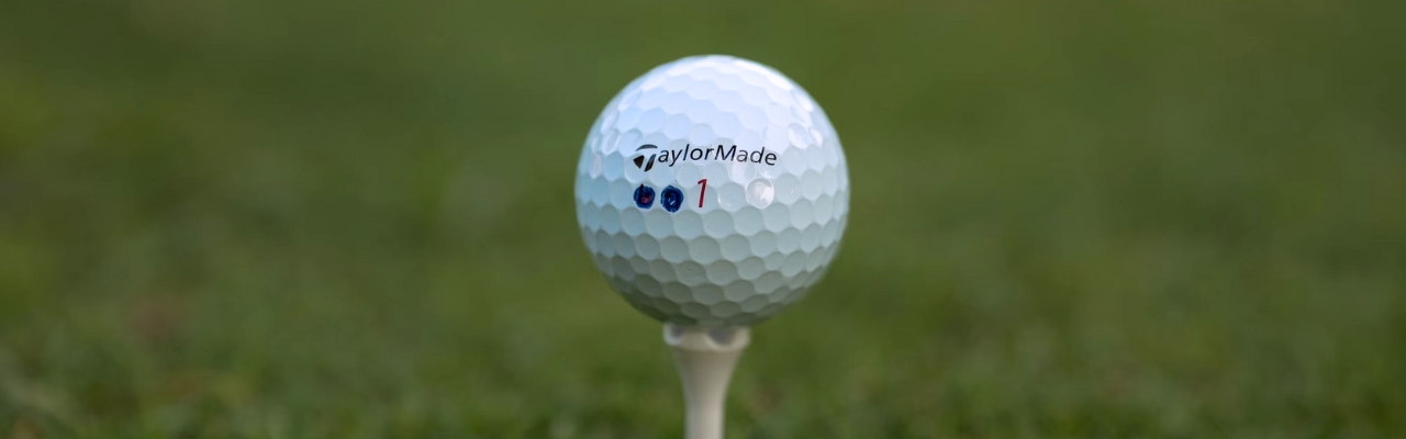 Image of a used TaylorMade golf ball on a tee