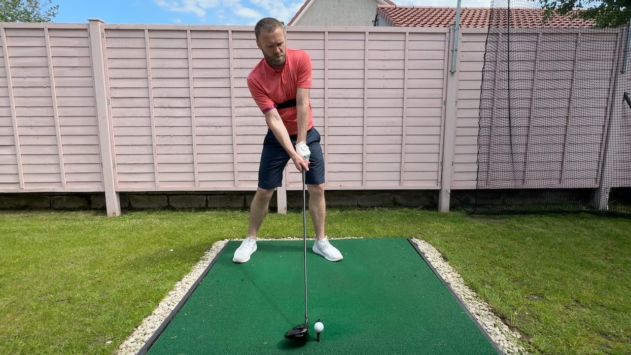 Andy setting up to hit a driver whilst wearing the TRS Slider swing training aid.