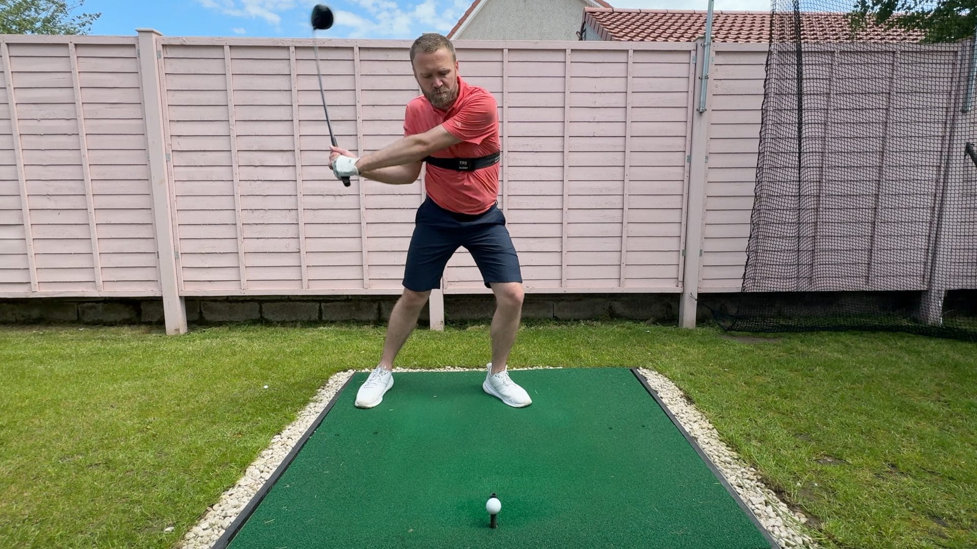Trail elbow tucked in on the downswing with driver whilst using the TRS Slider swing training aid.