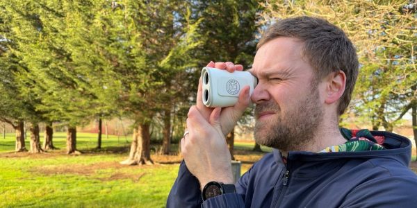 Andy looking through the Shot Scope PRO X laser rangefinder on the golf course.